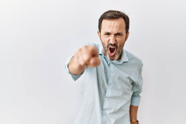 Orta yaşlı, sakallı bir adam izole edilmiş arka planda dikiliyor. Kameraya kızgın ve sinirli olduğunu gösteriyor. 