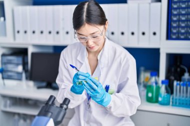 Laboratuvarda test tüpüne yazı yazan Çinli kadın bilim adamı.