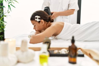 Genç Latin kadın güzellik merkezinde sırt masajı yaptırırken rahatlamış.