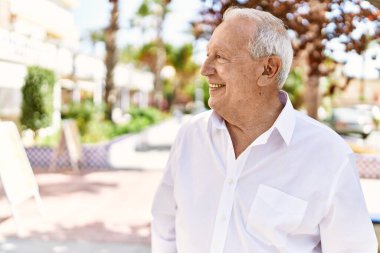 Güneşli bir günde kır saçlı son sınıf öğrencisi dışarıda mutlu mesut dikiliyor. Emeklilik için 70 'lerinde mutlu bir gülümseme.