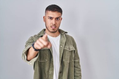 Genç İspanyol adam izole edilmiş arka planda dikiliyor. Kameraya kızgın ve sinirli olduğunu gösteriyor. 
