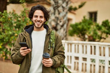Şehirde akıllı telefon kullanan yakışıklı bir İspanyol.