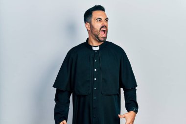 Sakallı yakışıklı, Katolik rahip cübbesi giymiş öfkeli ve kızgın bağıran sinirli ve öfkeliydi. Öfkeyle bağırıyordu. öfke ve agresif konsept. 