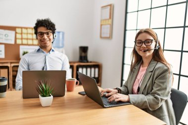 Ofiste çalışırken gülümseyen iki çağrı merkezi ajanı..