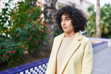 Young middle east woman executive standing with serious expression at park