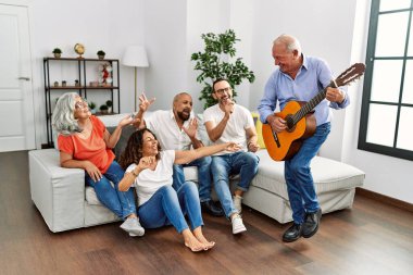 Bir grup orta yaşlı arkadaş evdeki kanepede oturup klasik gitar çalıyorlar..