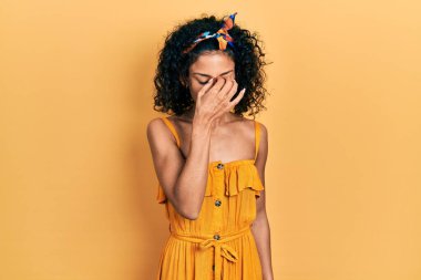 Yazlık elbise giyen genç Latin kız yorgun burnu ve gözleri ovuşturup yorgun ve baş ağrısı çekiyor. Stres ve hüsran kavramı. 