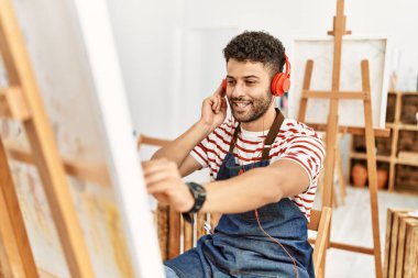Sanat stüdyosunda müzik dinleyen genç bir Arap sanatçı..