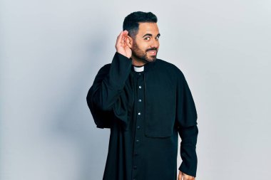 Sakallı, Katolik rahip cübbesi giymiş yakışıklı, ağzı kulaklarında dedikoduları ve dedikoduları dinleyen bir adam. Sağırlık kavramı. 