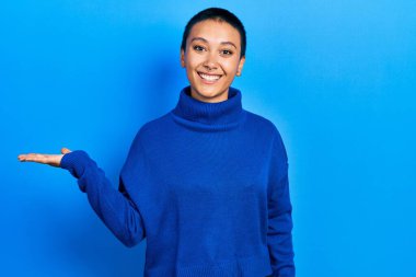 Kısa saçlı, balıkçı yaka kazaklı, güzel İspanyol kadın gülümseyen, eli avuçlarında kameraya bakan.. 