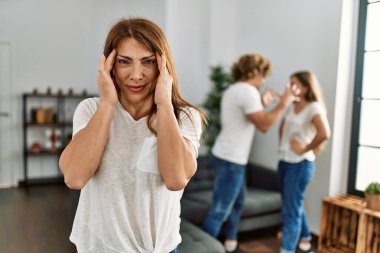 Anne ve baş ağrısı olan çift evde tartışıyor.