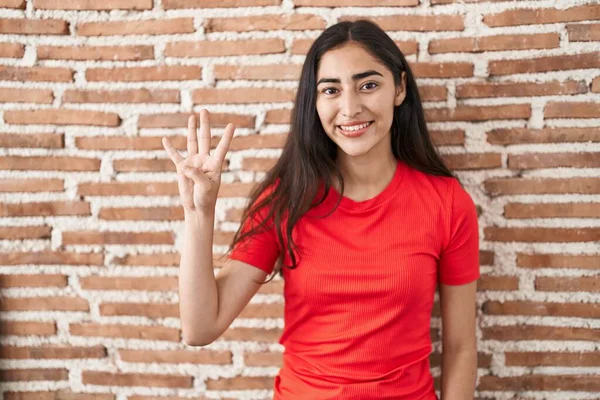Tuğla Duvarın Üzerinde Duran Genç Kız Dört Numarayı Gösterip Işaret — Stok fotoğraf