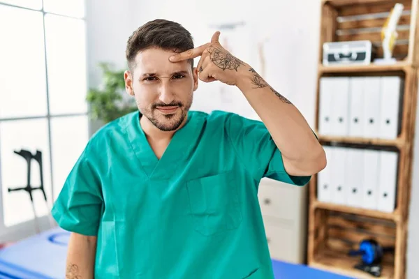 Young Physiotherapist Man Working Pain Recovery Clinic Pointing Unhappy Pimple — Stockfoto