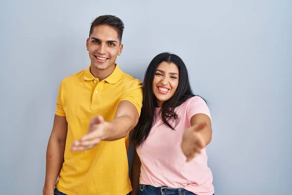 Giovane Coppia Piedi Sfondo Isolato Sorridente Allegra Offerta Mano Palma — Foto Stock