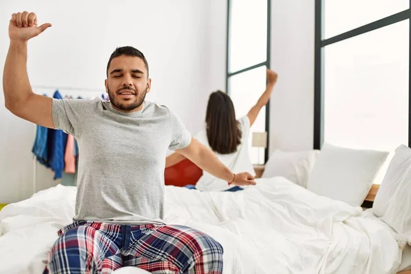 Junges Lateinisches Paar Gähnt Und Streckt Arme Auf Dem Bett — Stockfoto