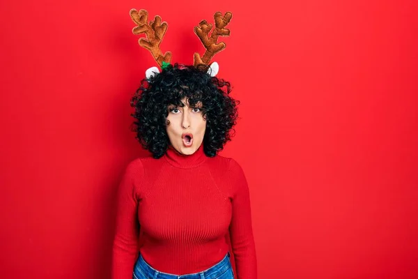 Young Middle East Woman Wearing Cute Christmas Reindeer Horns Afraid — стоковое фото