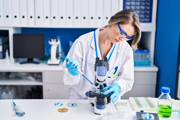 Young Woman Scientist Pouring Liquid Sample Using Microscope Laboratory —  Fotos de Stock