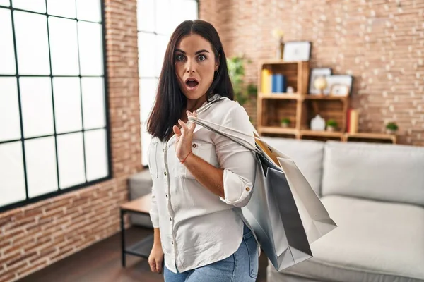 Young Hispanic Woman Holding Shopping Bags Scared Amazed Open Mouth — Stock Photo, Image