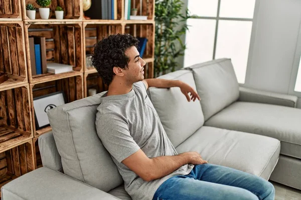 年轻的惊慌失措的男人高兴地坐在家里的沙发上 — 图库照片