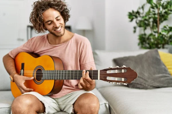 Ung Latinamerikansk Man Ler Glad Spelar Klassisk Gitarr Sitter Soffan — Stockfoto