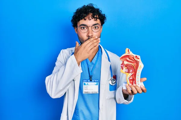 Young hispanic man wearing doctor uniform and stethoscope looking to side, relax profile pose with natural face with confident smile.