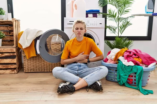 Young Blonde Woman Doing Laundry Sitting Washing Machine Hand Stomach — Stockfoto