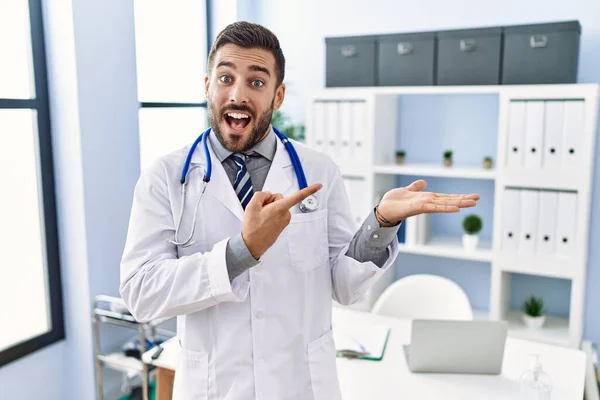 Hombre Hispano Guapo Vistiendo Uniforme Médico Estetoscopio Clínica Médica Asombrado —  Fotos de Stock