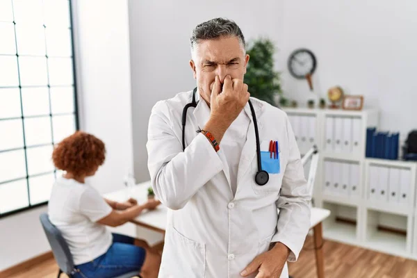 Middle Age Doctor Man Clinic Patient Smelling Something Stinky Disgusting — Stok fotoğraf
