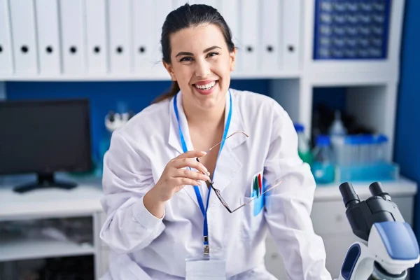 Young Hispanic Woman Scientist Smiling Confident Holding Glasses Laboratory — Φωτογραφία Αρχείου