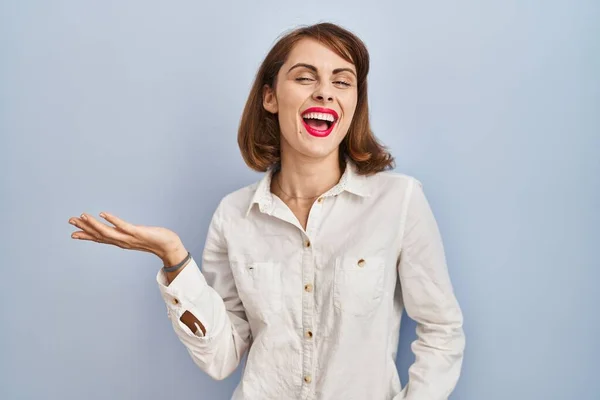 Young Beautiful Woman Standing Casual Blue Background Smiling Cheerful Presenting — Stock Photo, Image