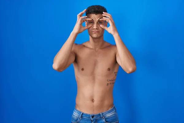 Молодий Іспаномовний Чоловік Стоїть Сорочки Над Синім Тлом Намагаючись Відкрити — стокове фото