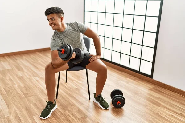 Giovane Uomo Ispanico Sorridente Allenamento Fiducioso Utilizzando Manubri Centro Sportivo — Foto Stock