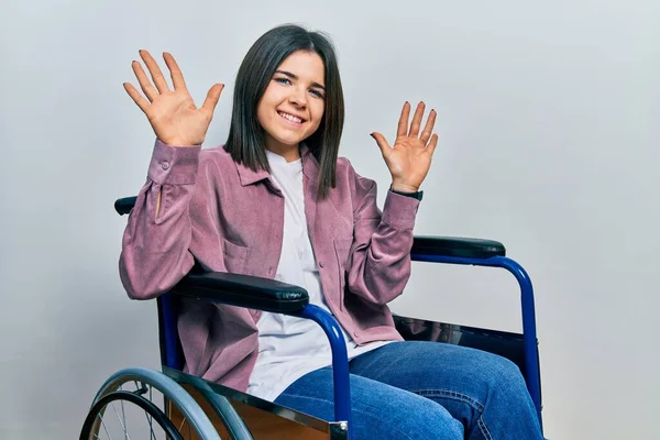 Young Brunette Woman Sitting Wheelchair Showing Pointing Fingers Number Ten — Foto de Stock