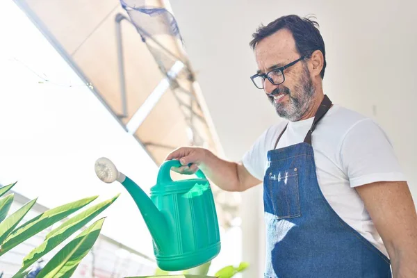 Middelbare Leeftijd Man Glimlachend Zelfverzekerde Besproeiende Planten Terras Thuis — Stockfoto