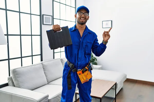 Young Indian Technician Holding Toolbox Screwdriver House Smiling Happy Pointing — Stockfoto
