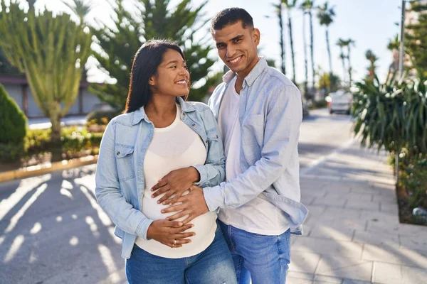 一对年轻的拉丁夫妇在公园等着宝宝摸肚子 — 图库照片