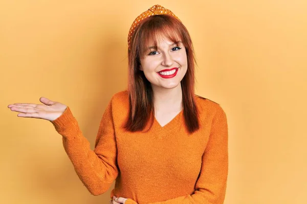 红头发的年轻女人穿着休闲的橙色毛衣 笑容满面 手指手画脚地看着相机 — 图库照片