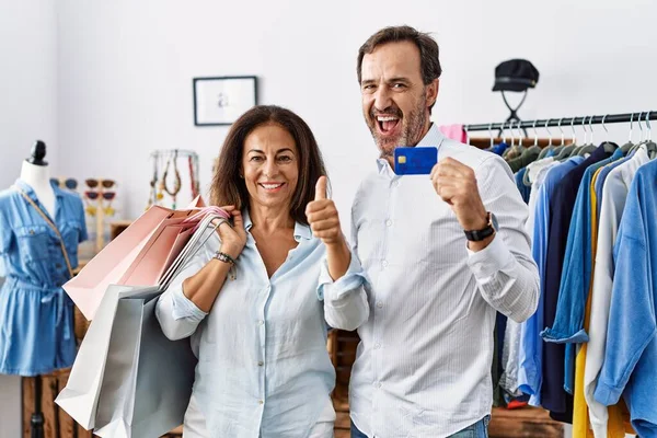 Hispanic Middle Age Couple Holding Shopping Bags Credit Card Approving — Stock fotografie