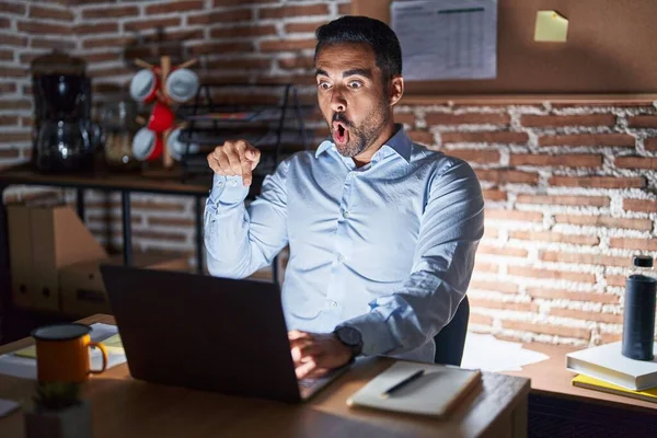 Hispánec Plnovousem Který Noci Pracuje Kanceláři Ukazuje Prstem Reklamu Překvapený — Stock fotografie