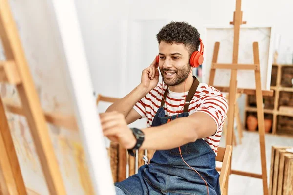 Sanat stüdyosunda müzik dinleyen genç bir Arap sanatçı..