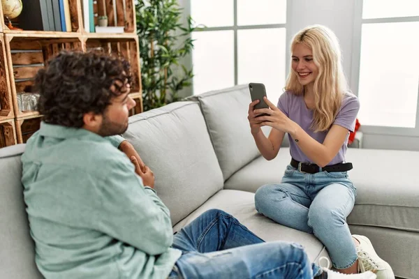 Jovem Mulher Fazendo Foto Seu Namorado Usando Smartphone Casa — Fotografia de Stock