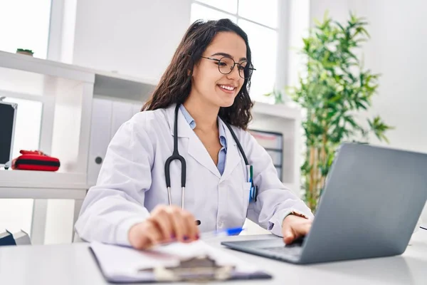 Young Hispanic Woman Wearing Doctor Uniform Using Laptop Working Clinic — Stock Photo, Image