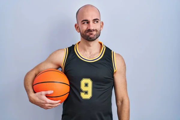 Mladý Plešatý Muž Vousy Basketbalové Uniformě Drží Míč Úsměvem Stranou — Stock fotografie