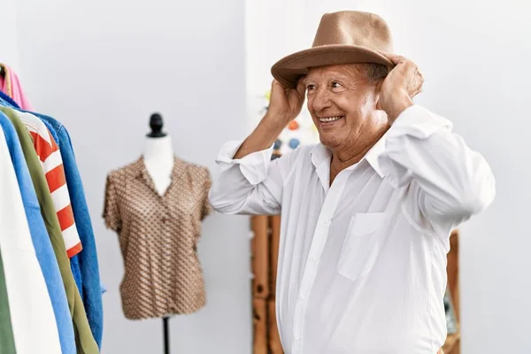Senior man customer wearing hat at clothing store