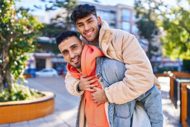 Parkta birbirine sarılan iki erkek sevgili.