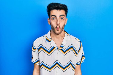 Gündelik kıyafetler giyen genç İspanyol adam dudaklarıyla balık suratı yapıyor, çılgınca ve komik bir jest. Komik ifade. 