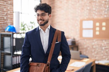 Young hispanic man business worker smiling confident standing at office