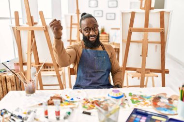 Sanat stüdyosunda kızgın ve kızgın bir Afrikalı Amerikalı sanatçı öfkeyle bağırırken yumruğunu sallıyor ve öfkeleniyor. öfke ve agresif konsept. 