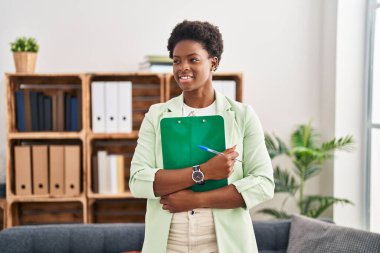 African american woman psychologist holding clipboard at psychology center