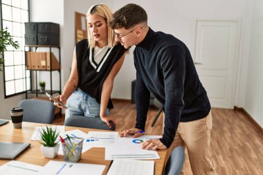 Ofiste çalışan akıllı telefon kullanan iki ciddi yüzlü iş adamı..